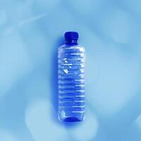 Clear plastic water bottle for water half litre on light blue background closeup, minimal style object, aesthetic top view, Pollution, environmental protection. Eco trend to reduce disposable plastics photo
