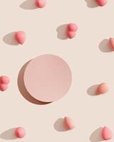 Makeup sponges around circle pink podium on beige with shadow at sunlight. Cosmetic background for product presentation or foundation cream. Top view sponges and stand to show cosmetic products photo