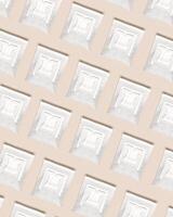 Drip coffee bags with ground coffee for brewing in cup, package with paper bag drip coffee filter on beige color background, top view, minimal flat lay, geometric pattern photo
