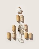 Wine corks shaped Christmas Tree with star on beige background, hard light at sunlight. Bottle stoppers as xmas, New Year tree. Winter celebration holidays concept, Christmas flat lay photo