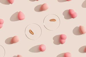 Top view swatches from tone cream and makeup puff. Beauty blender make up sponge for foundation cream, and samples on glass disk, sponges on beige background. Skincare beauty product photo