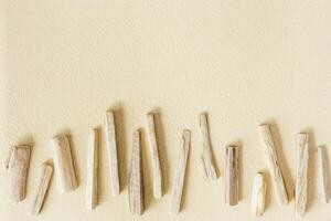 Aesthetic minimal pattern from old pieces of wood on sand, beautiful sandy texture, natural background, concept of harmony, balance and meditation, relaxation. Top view, summer flat lay photo