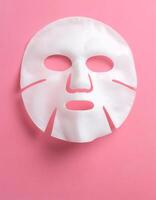 Self-Care and Wellness White Sheet Mask on Pink Background photo