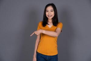 Smiling Portrait of a Young Girl Pointing Down with Joyful Expression Isolated photo