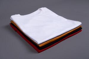 A stack of folded t-shirts against a grey background photo