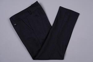 Black folded pants on a grey background photo