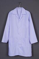 White folded laboratory coat hanging on hanger on a grey background photo