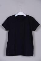 Minimalist Black T-Shirt Mockup Hanging on Hanger Against a Grey Background photo