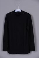 Versatile Black Knit T-Shirt for Branding Design Hanging on Hanger Against a Grey Background photo