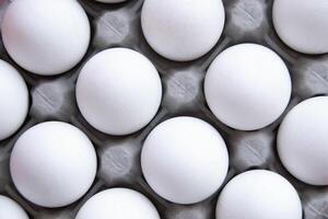 Dozen Fresh White eggs, neatly stacked in Cardboard Tray Top View, create aesthetic Minimalism, Uniformity Purity. Food-related projects, creating corporate identity market decorating kitchen photo