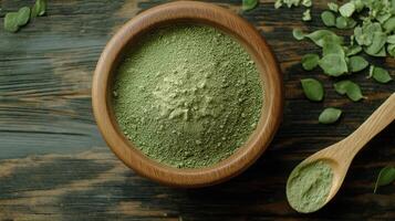 Moringa powder in a wooden bowl on a wooden table photo