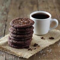 A stack of chocolate cookies with salt on a wooden table photo
