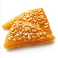 Two pieces of caramel covered in seeds photo