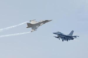 Two fighter jets flying in the sky with smoke coming out of them photo