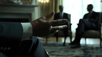 The diplomat gestures subtly with one hand extended emphasizing a point during a discussion. The camera captures the luxurious textures of the chairs and the distant silhouettes o photo