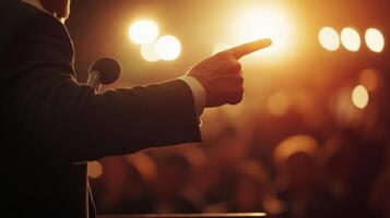 The camera zooms in on a politicians hands as they emphatically point towards the audience conveying urgency. The soft blur of lights behind them reinforces the dynamic energy of thei photo