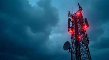 Cell tower with red lights on it against a cloudy sky photo