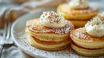 Fluffy Buttermilk Pancakes Topped With Whipped Cream and Sprinkles on a White Plate photo