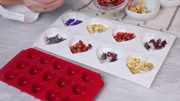 Preparation of colorful ingredients for chocolate forms in the form of a heart with various fillings video