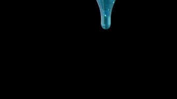 A light blue, viscous liquid steadily flows downwards from the top against a black background. The slow movement highlights the texture and smooth descent of the fluid. video