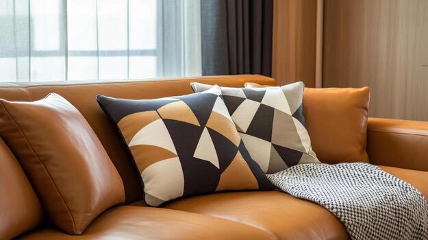 A couch with two pillows and a blanket photo