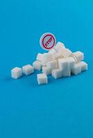 Sugar cubes piled with a warning sign against excessive consumption photo