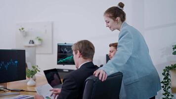 Team collaborating on financial analysis in modern office environment with multiple screens displaying data video