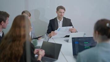 Team collaborates in conference room to review project documents and discuss strategies video