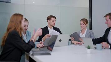 Team discussions take place in modern office setting during morning meeting hours with technology usage video