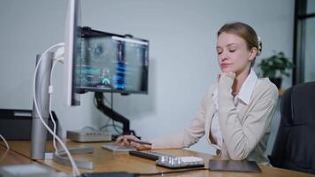 Young woman working on a computer in a modern office, focused on data analysis and tasks video
