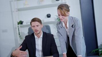 Professional collaboration in modern office space involves analysis and teamwork while working on a laptop and using data charts video