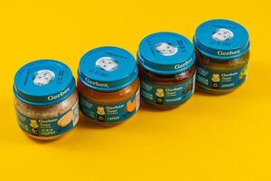 Lviv Ukraine 04.02.25 Healthy baby food jars arranged on yellow background photo