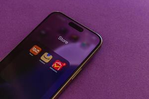 03.26.25 Lviv Ukraine Mobile device displaying app store interface on purple surface photo