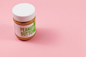 Lviv Ukraine 04.02.25 Peanut butter jar on a pink background photo