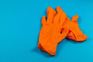 Orange gloves resting on a blue surface photo