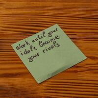 Inspirational reminder on a sticky note placed on a wooden table photo