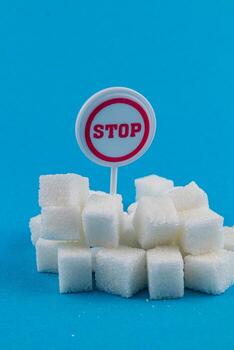 Sugar cubes stacked with a stop sign indicating limits on consumption photo