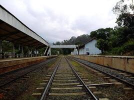 Completely empty railway station in Ella Sri Lanka with tracks and a bridge under a cloudy sky photo