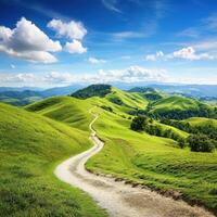 Scenic winding path through green hills under blue sky photo
