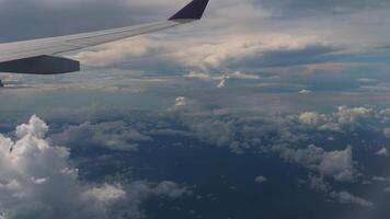 First-person view from an airplane window as it flies above the clouds, capturing the vast sky and soft clouds below. Themes of adventure, aviation, and freedom. video