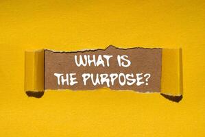 What is the purpose message written on ripped torn yellow paper on brown background. Conceptual what is the purpose symbol. Copy space. photo