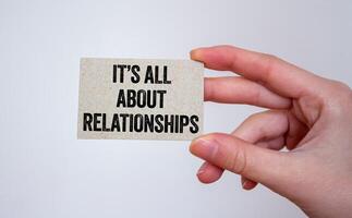 It is all about relationships message written on a card in hand. Conceptual it is all about relationships symbol. Copy space. photo