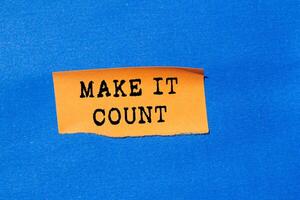 Make it count message written on ripped torn orange paper on blue background. Conceptual make it count symbol. Copy space. photo
