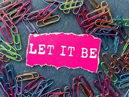 Let it be message written on ripped torn pink paper piece on grey background. Conceptual let it be symbol. Copy space. photo