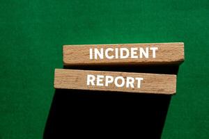 Incident report message written on wooden blocks on green background. Conceptual incident report symbol. Copy space. photo