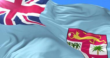Flag of Fiji waving at wind with blue sky in slow, loop video