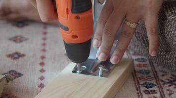 Installing hardware on a wooden board with a power tool video