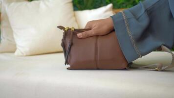 Stylish brown leather bag displayed in a cozy outdoor setting video
