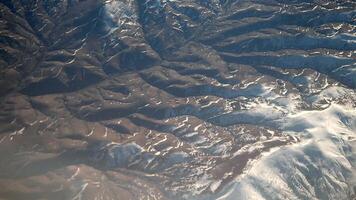 Snow-capped mountain range viewed from an airplane window video