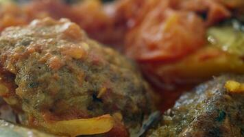 Savory meatballs served with roasted vegetables in a warm dish video